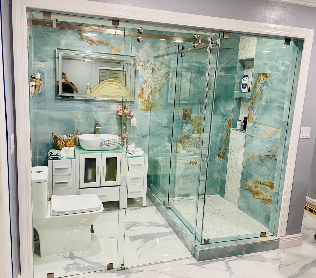 Glass shower enclosure with blue stone walls