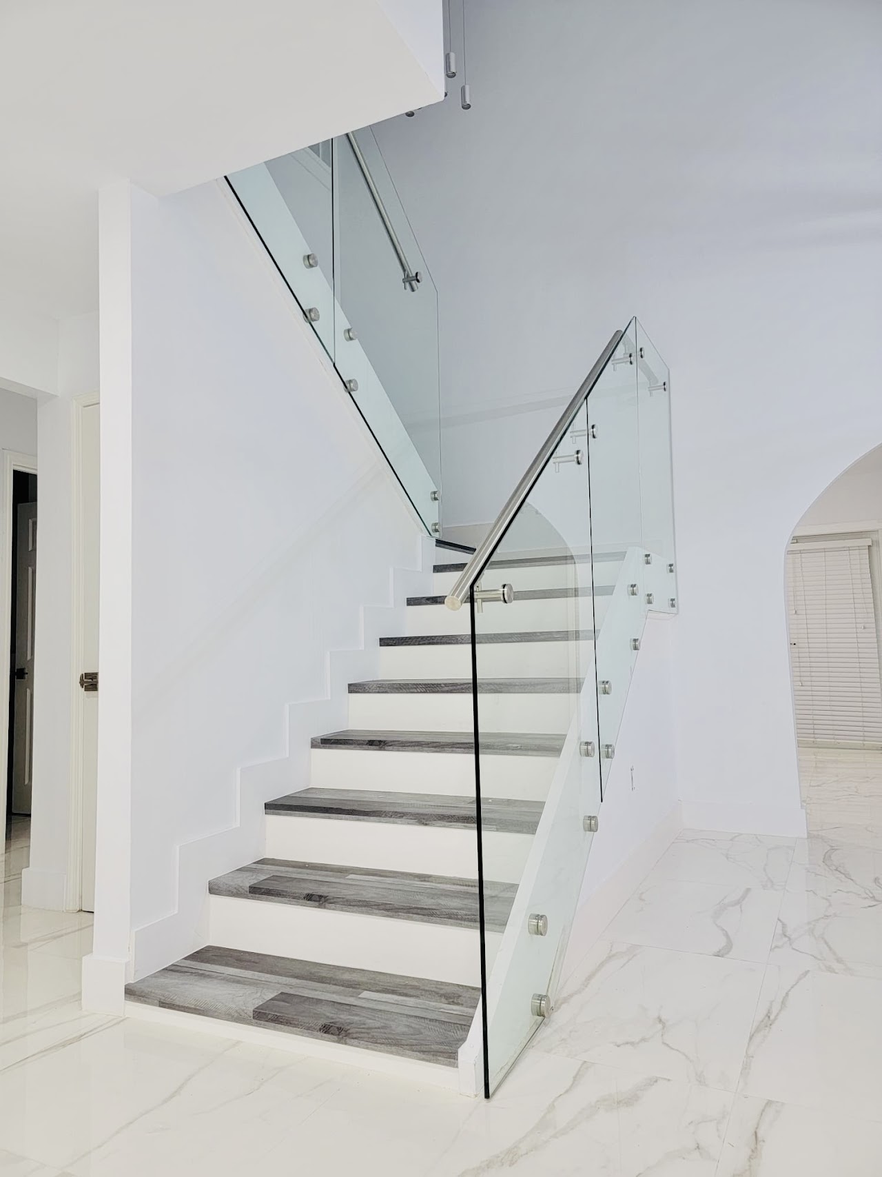 Glass railing and handrail on white staircase